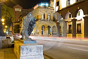 Night scene in Old Havana with a famous bronze lion considered a symbol of the city