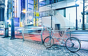 Night scene with parked bicycle and blurred speeding car in the