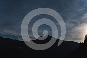 Night scene in the Polish Tatras. Mount Kasprov, cable road for the funicular, twilight and starry sky with a slight haze