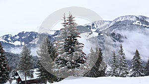 Night scene of street lamp and pathway covered with snow and moon over hill. Tranquil scene. Gruyeres, Switzerland