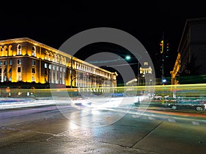 Night scene of tram in traffic at crossing with lighttrail motion blur