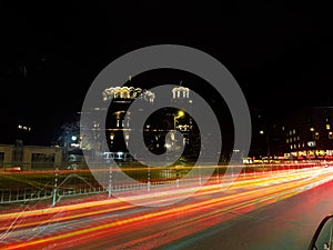 Night scene of tram in traffic at crossing with lighttrail motion blur