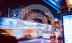 Night scene of tram in traffic with lighttrail motion blur