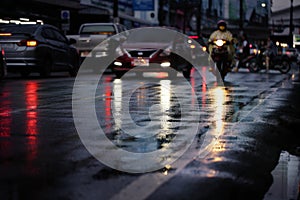 Night scene of wet street after hard rain fall in the city with blurry cars.