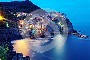 Night scenery of Manarola, an amazing village on vertical cliffs by the rocky coast in Cinque Terre National Park