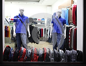 Night shop window with men dressed mannequins. Evening lihgt