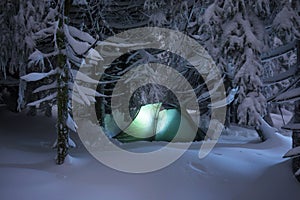Night shot camping, long exposure, sleeping in the snow outside. Night bivouac in the mountains. Christmas time.