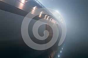 Night shot of a bridge in thick fog.