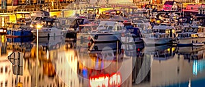 Night shot of a lit harbor on the Teltow Canal in Berlin-Tempelhof with boats and reflections on the water