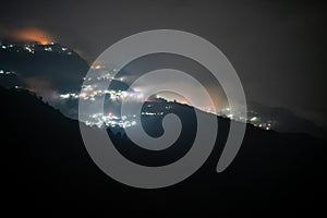 Night shot showing darjeeling village nestled in the middle of himalaya mountains with orange and blue light