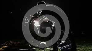 Night shot of two mans erecting tent in ligh from expeditionary SUV.