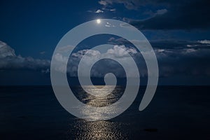 Night sky with full moon and reflection in sea, beautiful clouds.