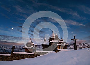 Night sky mith Moon above countryside remote village church on hill top. Ukraine, Voronenko