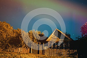 Night sky over house in old village. Night starry sky above house with bright stars and meteoric track trail. Glowing