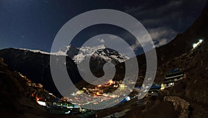 Night sky and stars passing by behind mountain Kongde Ri, Namche Bazaar village. Nepal photo