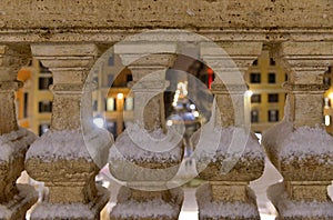 Night snowfall on empty Spanish square and steps in Rome with church Trinita di Monti in background, Italy. Piazza di Spagna