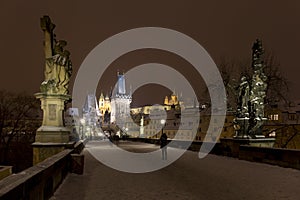 Night snowy colorful Prague Lesser Town with gothic Castle, St. Nicholas` Cathedral from Charles Bridge, Czech republic