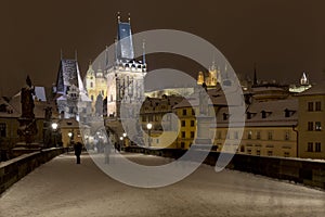 Night snowy colorful Prague Lesser Town with gothic Castle, St. Nicholas` Cathedral from Charles Bridge, Czech republic