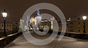 Night snowy colorful Prague Lesser Town with gothic Castle, St. Nicholas` Cathedral from Charles Bridge, Czech republic