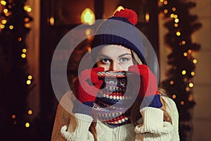 Night street portrait of young beautiful woman in classic stylish warm winter knitted clothes with scarf covering her