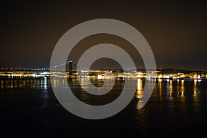 Night Tejo river. 25thth April bridge. Lisbon. Almada. Portugal. Nightscene. lights  colors dark background. landscape