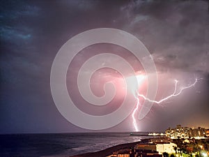 Night thunderstorm and lightning blots over the sea near the coast