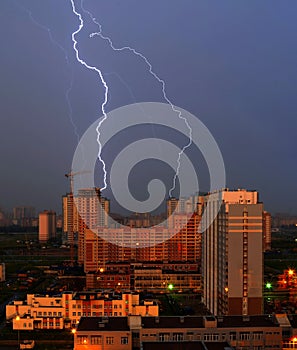Night thunderstorm over the city and lightning strikes in high-rise building
