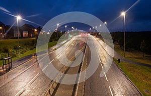 Night time dual carriageway in UK with LED street lighting and wet roads