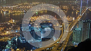 Night time-lapse skyview with container port traffic in Hong Kong. pan up