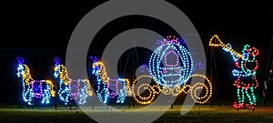 night time light show Cinderella with three horses drawing carriage and man blowing trumpet