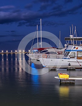 a night time shot of some boats and water with many lights on