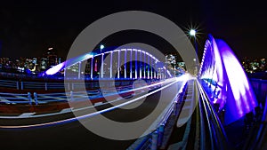 A night timelapse of city street near the illuminated bridge in Tokyo wide shot