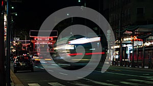 night timelapse of traffic Along Shijo Dori with West Tower Gate main entrance to Yasaka-jinja Shrine in