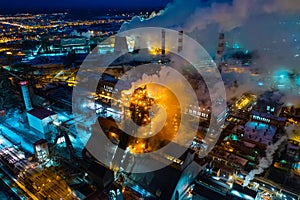 Night top view of a steel mill. Smog, smoke and flame from chimneys. Metallurgical blast furnace in lights and smoke