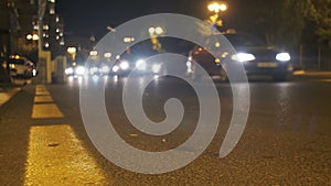 Night Traffic in the City. Defocused Cars Drive with Lights on Night Road.