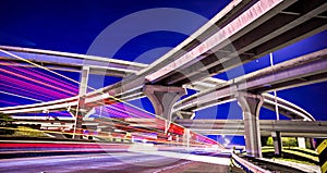 Night traffic with light trails on highway interchange