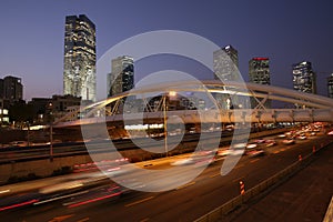 Night traffic in Tel Aviv. modern metal bridge in the city in the downtown over the highway and railway. concept of modern enginee