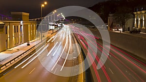 Night traffic time lapse. Traces of headlights and brake lights. Zoom in