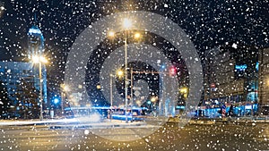 Night traffic timelapse on city street in winter, falling snow