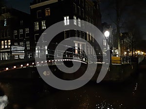 Night trip in the dark between the canals and the busy streets of amsterdam