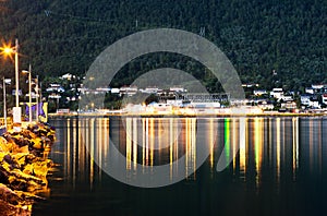 Night Tromso city pier with lamp reflections background