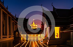 Night Urban City Skyline of Landmark Bangkok. Wat Saket. Night scene of Phu Khao Thong Golden Mountain and monk reading a book