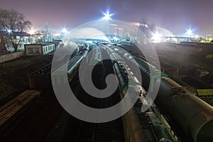 Night view from above on the railway. Commodity trains, freight wagons and cisterns