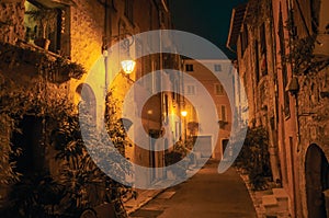 Night view of alley with walls and stone arches in Vence.