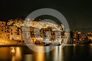 Noche de Playa en Sicilia, iluminado viejo vistoso terraplén casas el mar a acantilado 