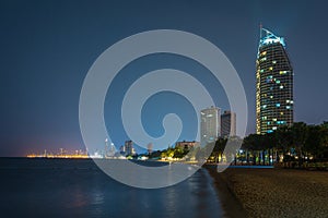 Night view of a beautiful beach in Pattaya, Thailand with highrises and city lights in background