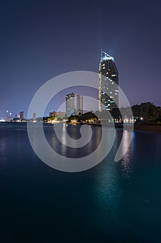 Night view of a beautiful beach in Pattaya, Thailand with highrises and city lights in background