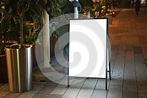 Night view of a blank billboard in front of the restaurant-cafe