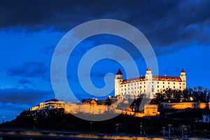 Night view of Bratislava castle from river surface with dramtic sunset skyline