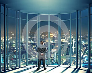 Night view of buildings and man from glass window